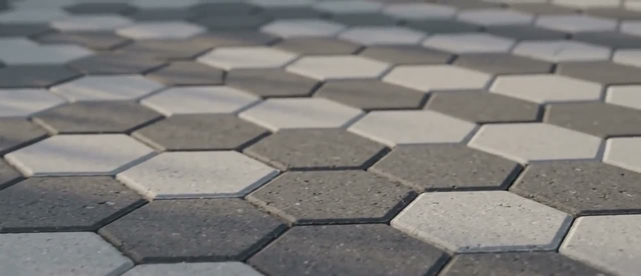 Caminho pavimentado com bloquetes sextavados assentados em fiada fechada